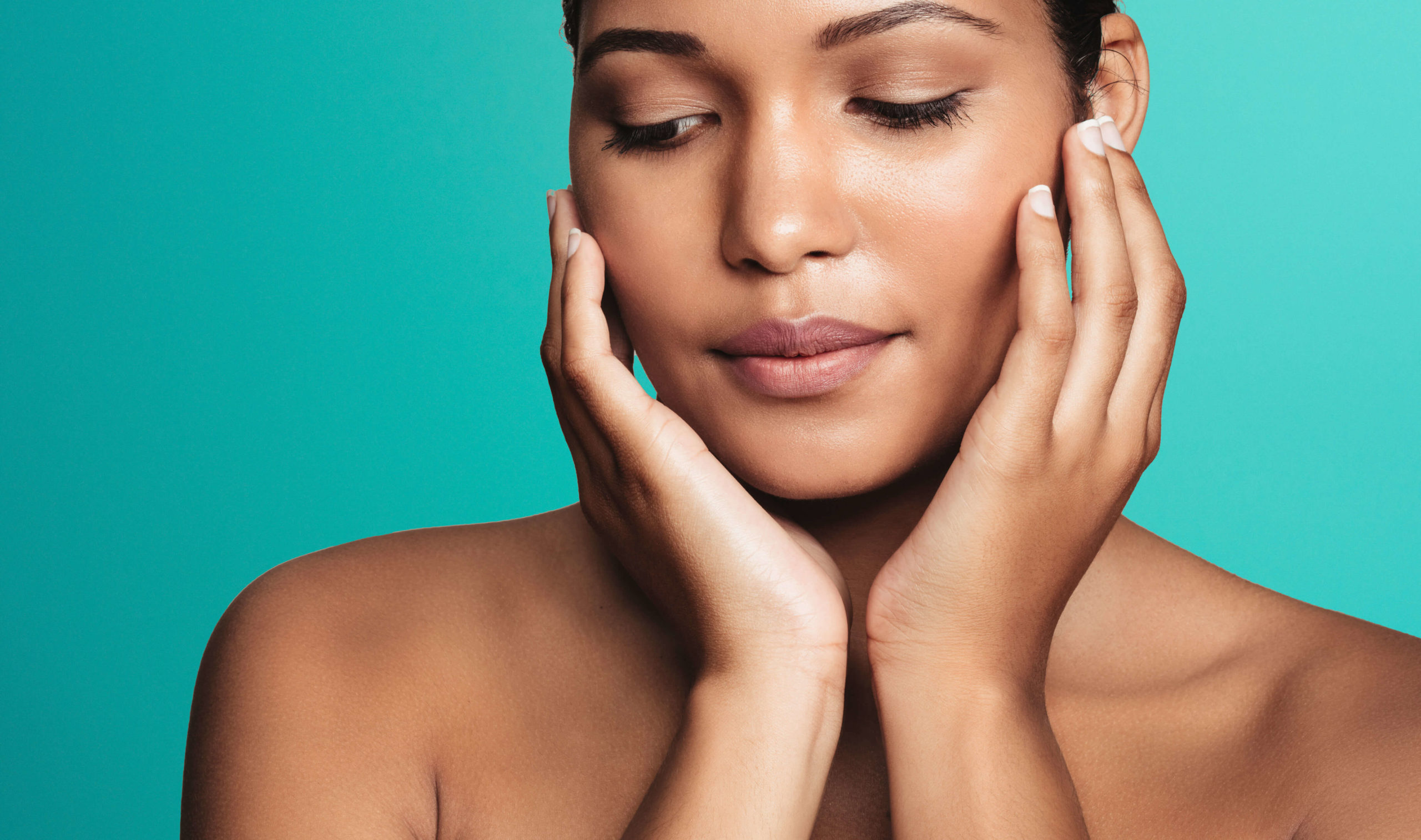 Sofwave ultrasound skin lifting Amsterdam - close-up of a woman with eyes closed framing Close-up of a woman with eyes closed framing her face with both hands against for Sofwave ultrasound skin lifting in Amsterdam